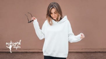 girl wearing a plain white hoodie, holding sunglasses in her right hand, custom hoodie design ideas