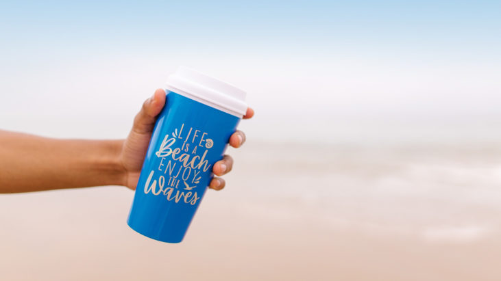 a hand holding a blue tumbler that says "life is a beach enjoy the waves"