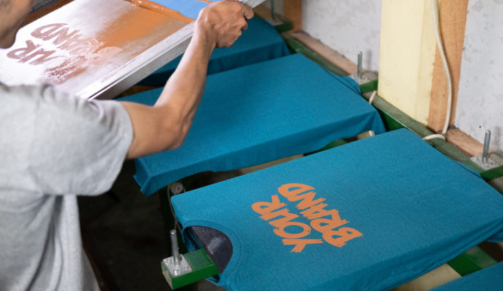 man screen printing blue t-shirts